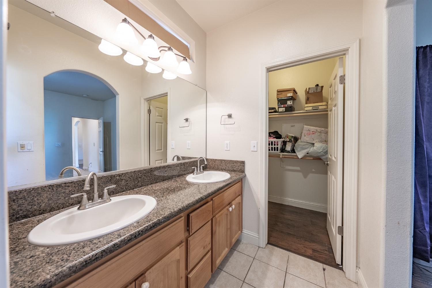 2727 Pear Tree Drive Madera, CA 93637 - Photo 18 of 36 a bathroom with a granite countertop sink a mirror and a shower