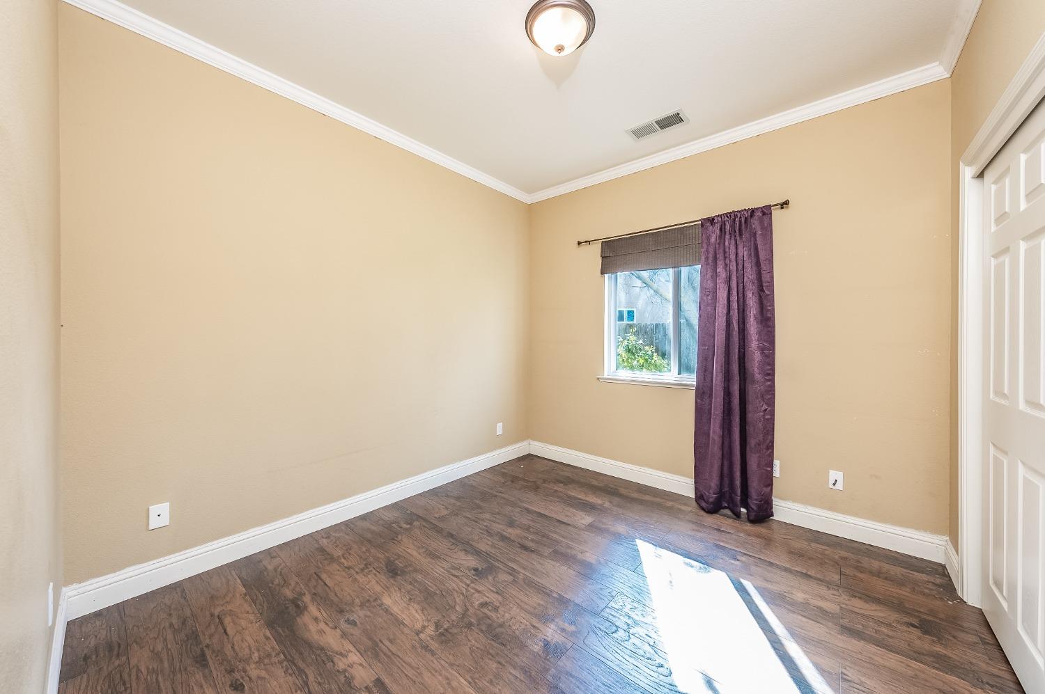 2727 Pear Tree Drive Madera, CA 93637 - Photo 19 of 36 a view of an empty room with wooden floor and a window