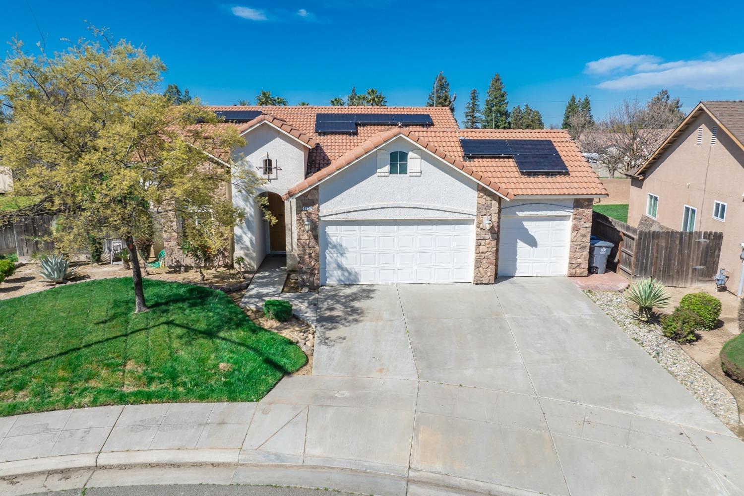 2727 Pear Tree Drive Madera, CA 93637 - Photo 30 of 36 a front view of a house with a yard and garage