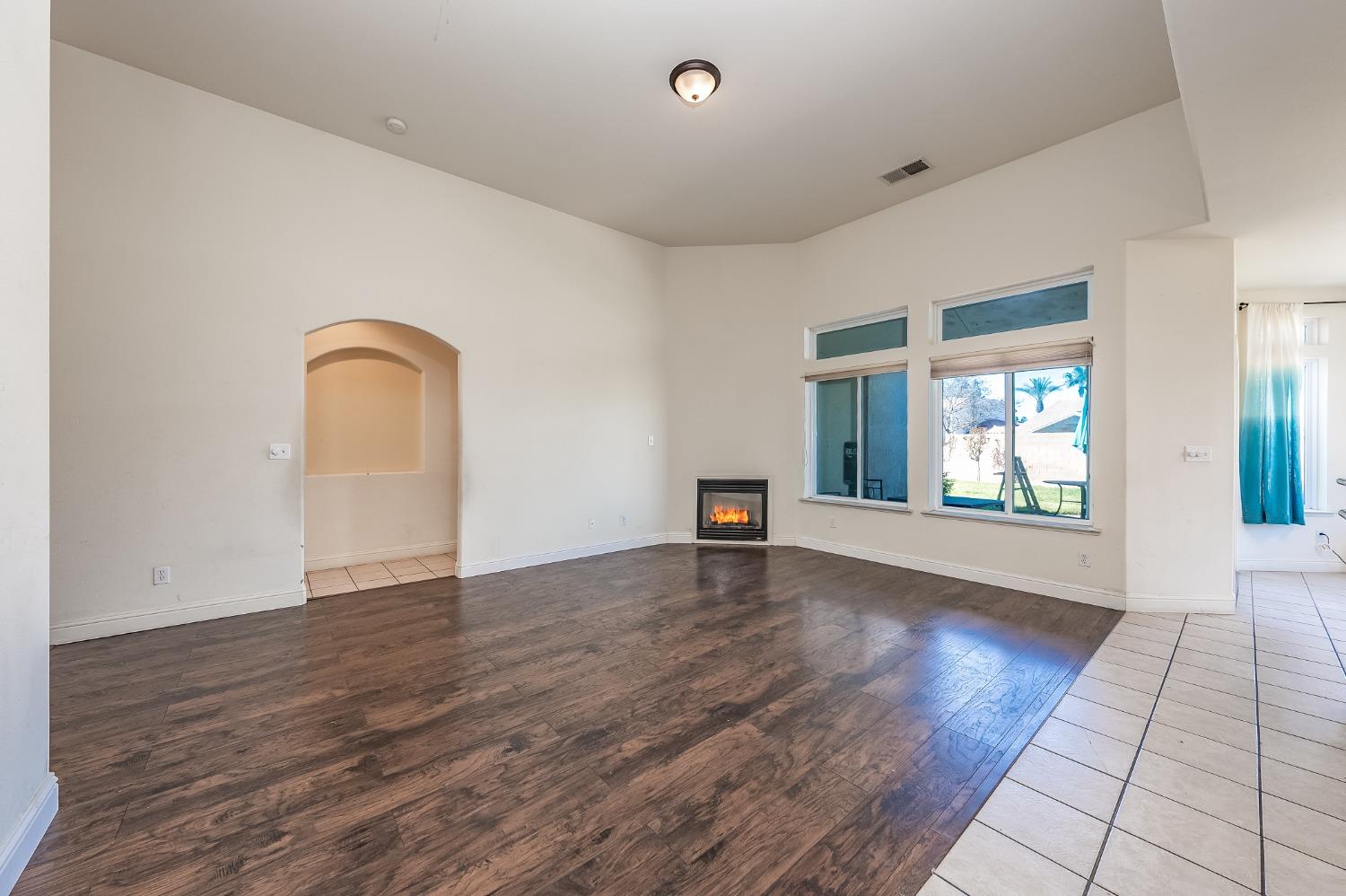 2727 Pear Tree Drive Madera, CA 93637 - Photo 6 of 36 a view of an empty room with wooden floor and a window