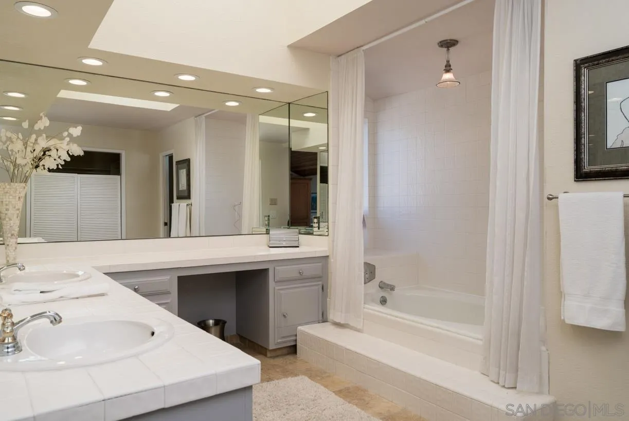 2310 Cordero Road Del Mar, CA 92014 - Photo 15 of 25 a bathroom with a bathtub a mirror a double vanity sink and