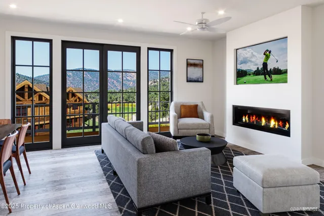 a living room with furniture a flat screen tv and a floor to ceiling window