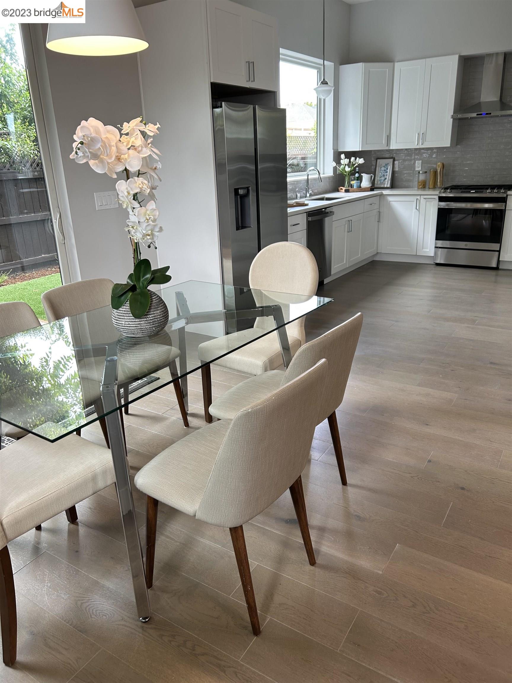 1677 12th Street Oakland, CA 94607 - Photo 3 of 15 a kitchen with stainless steel appliances dining table chairs and granite counter tops
