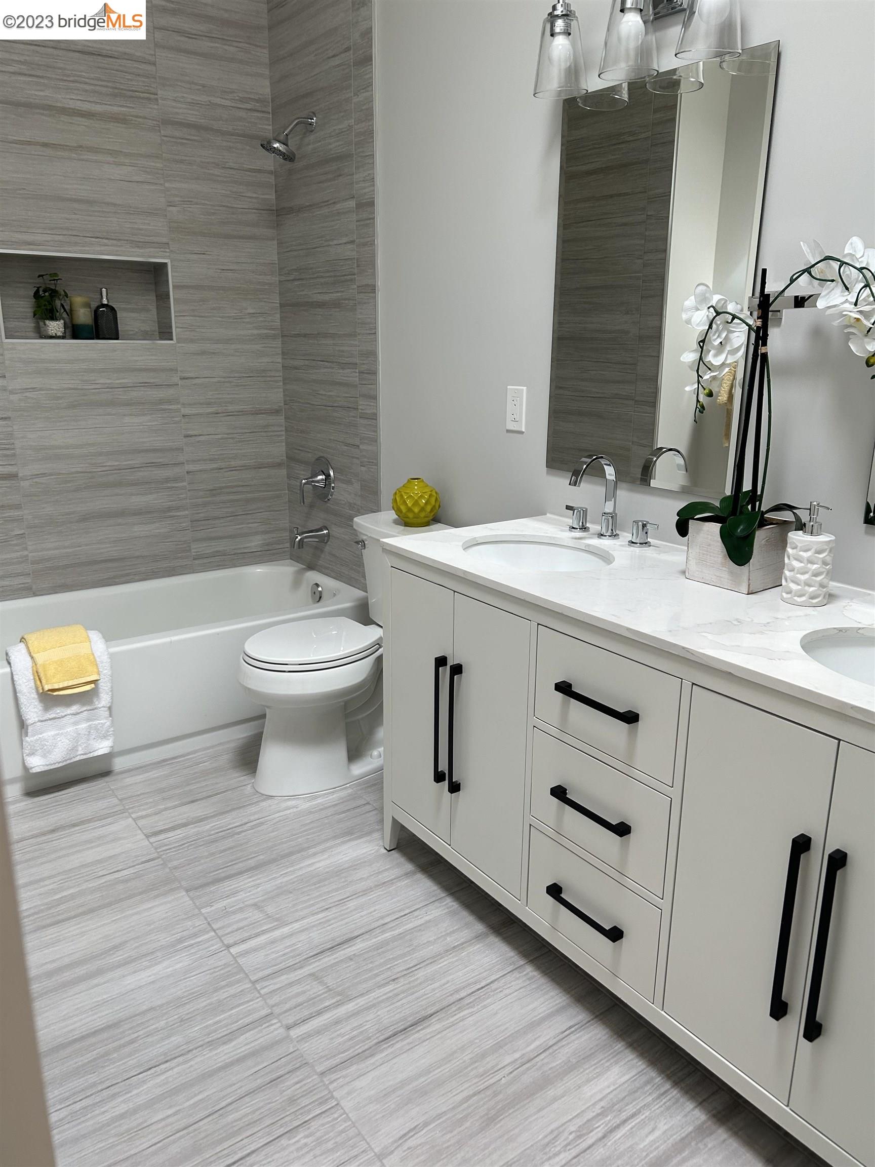 1677 12th Street Oakland, CA 94607 - Photo 8 of 15 a bathroom with a double vanity sink toilet and mirror