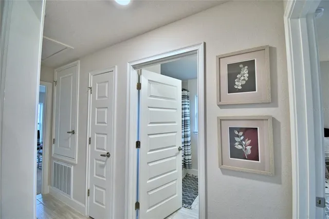 a bedroom with a bed and a lamp on dresser next to a window