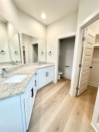 a spacious bathroom with a granite countertop sink a mirror and a vanity