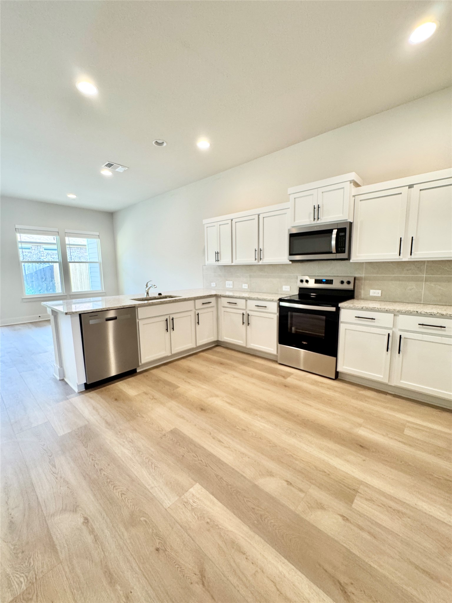 108 Zayd Court, Unit B Jarrell, TX 76537 - Photo 3 of 21 a large kitchen with stainless steel appliances granite countertop a stove and a sink