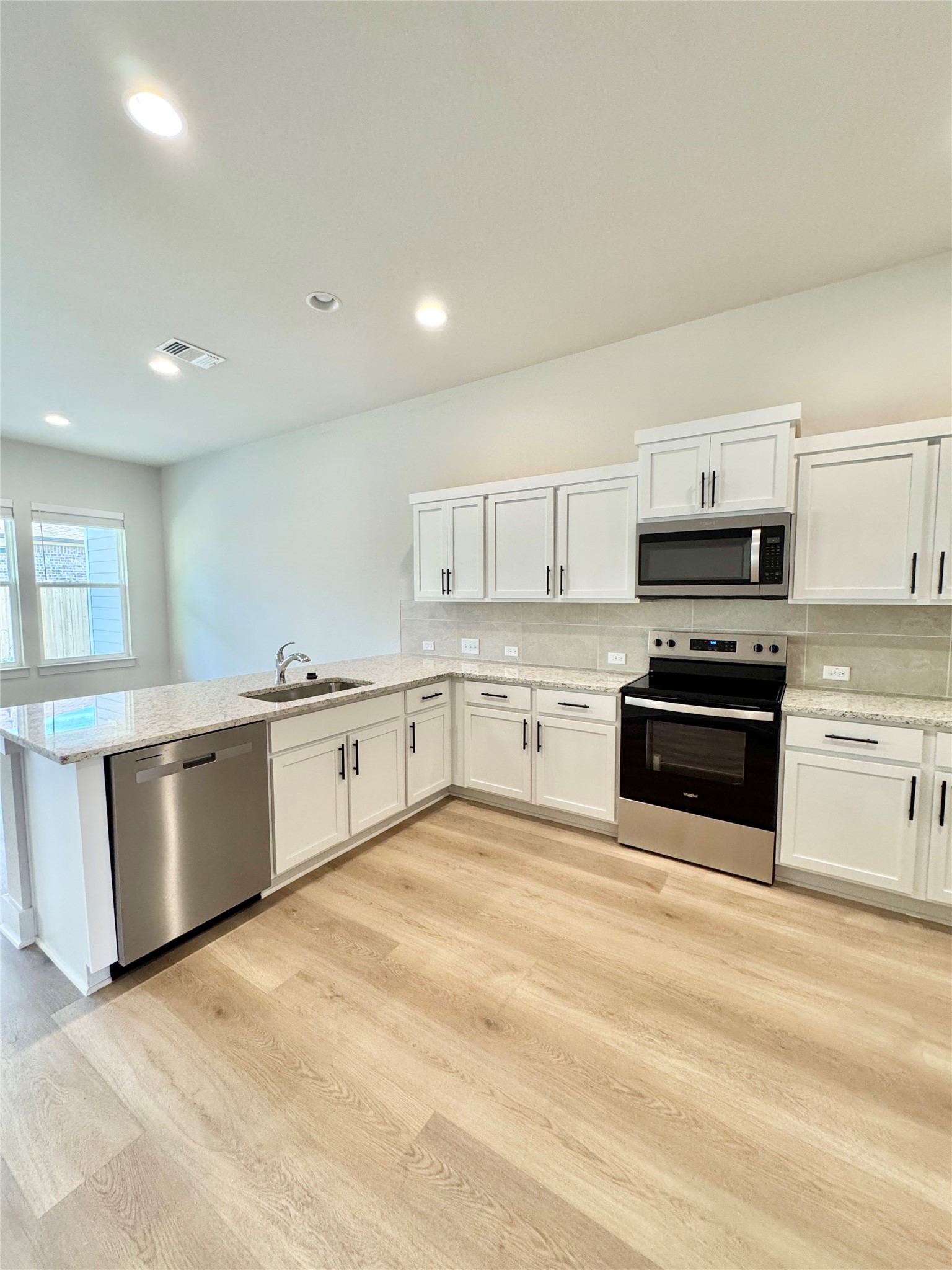 108 Zayd Court, Unit B Jarrell, TX 76537 - Photo 10 of 21 a large kitchen with granite countertop a stove top oven and cabinets