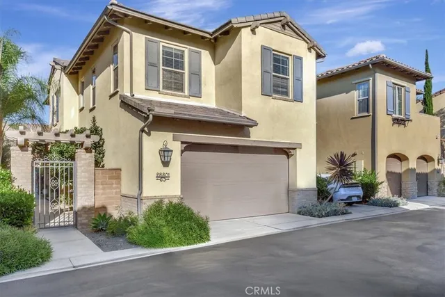 a front view of a house with a yard and potted plants