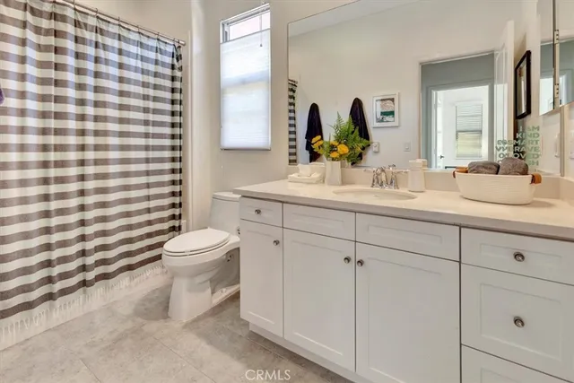 a bathroom with a double vanity sink toilet and mirror