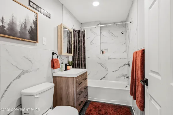 a bathroom with a sink toilet vanity and shower
