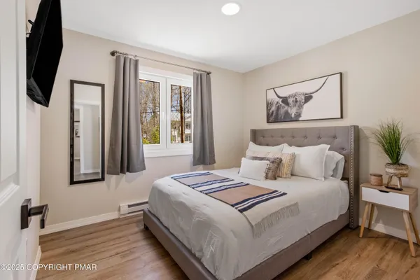 a bedroom with a bed a mirror and a flat tv screen