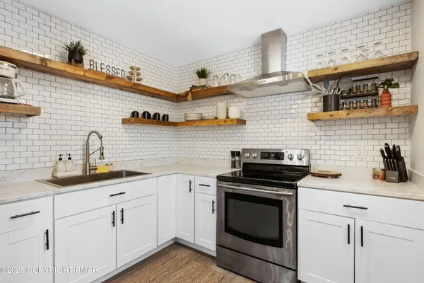 a kitchen with cabinets stainless steel appliances and wooden floor
