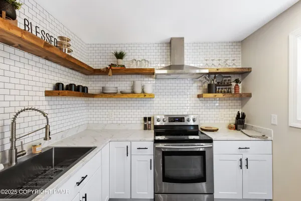 a kitchen with stainless steel appliances granite countertop a sink stove and cabinets