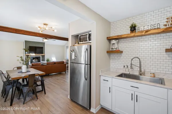 a kitchen with stainless steel appliances a refrigerator a sink a stove and white cabinets