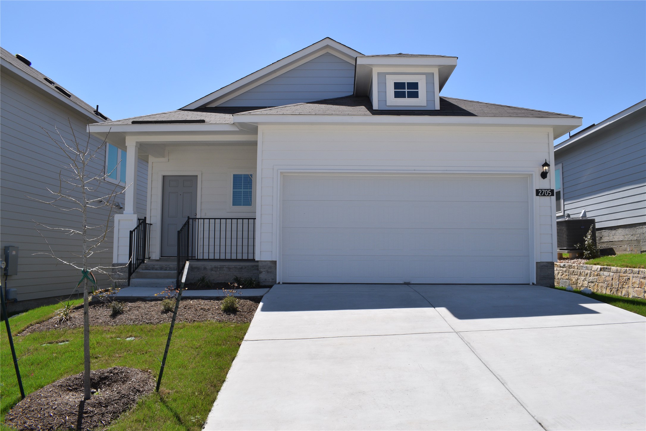 2705 Towy Road Manor, TX 78653 - Photo 1 of 30 View of front facade with concrete driveway, an attached garage, a front lawn, and roof with shingles