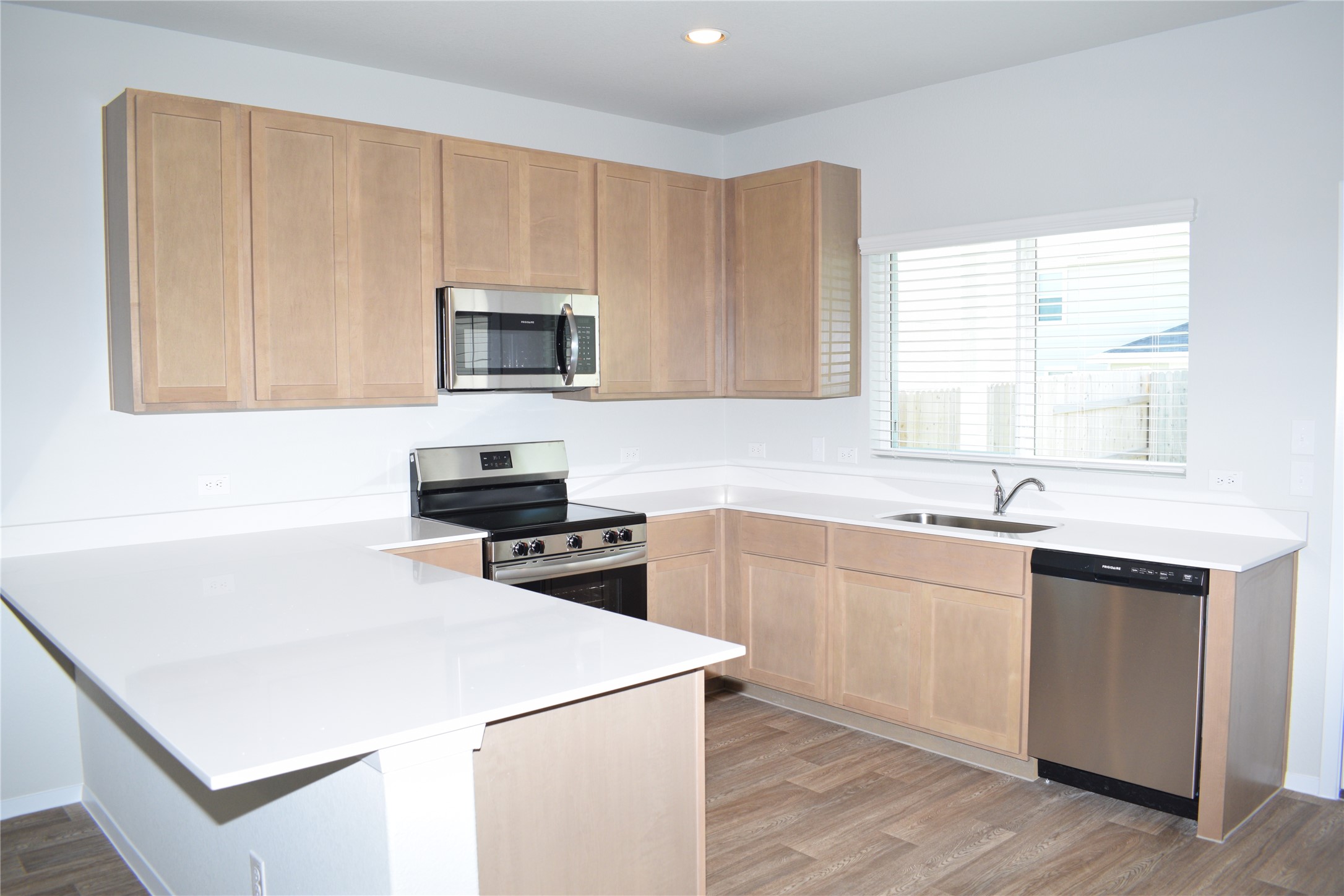 2705 Towy Road Manor, TX 78653 - Photo 6 of 30 Kitchen featuring stainless steel appliances, a peninsula, light wood-style flooring, recessed lighting, and light wood finish cabinets