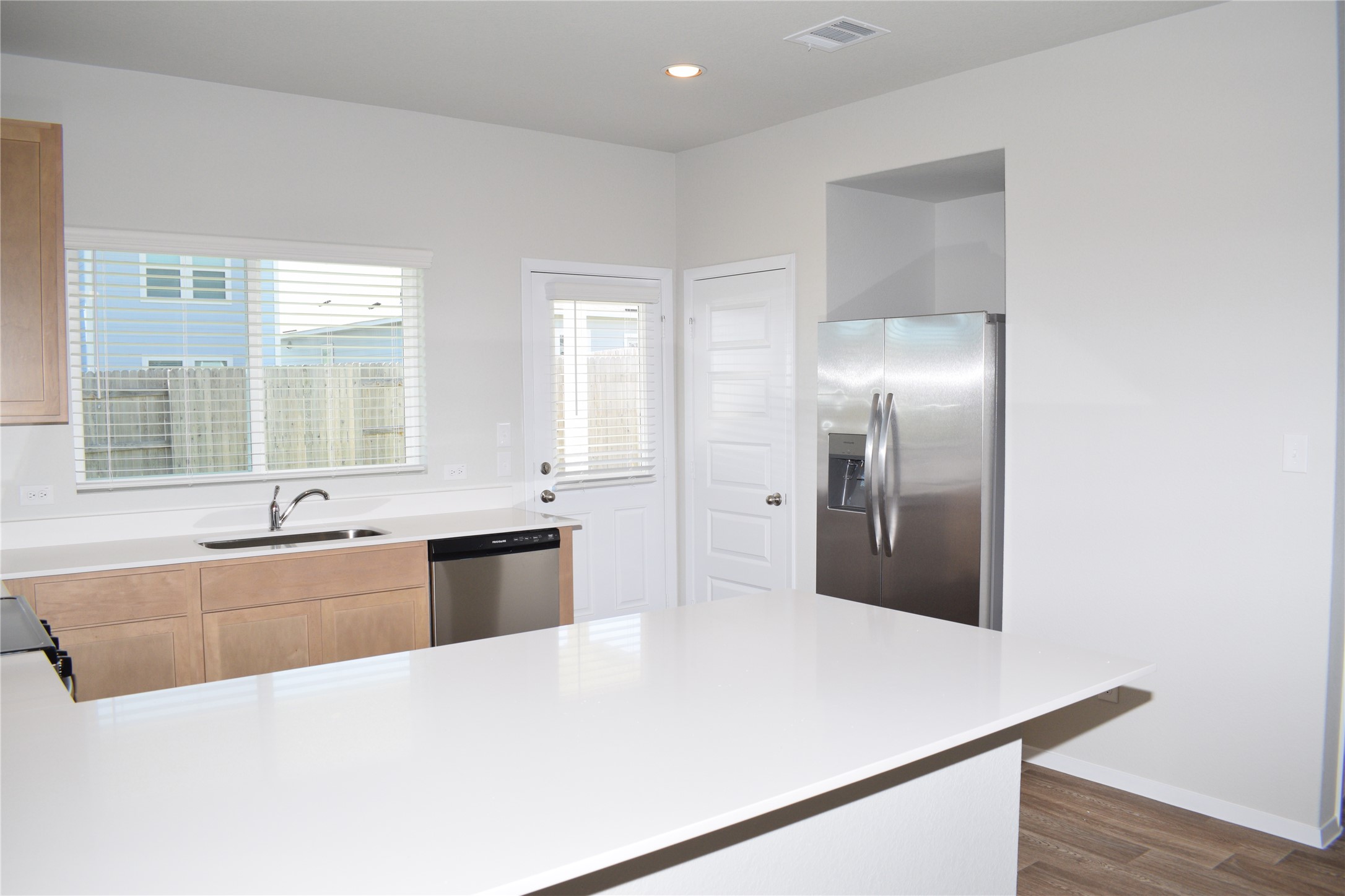 2705 Towy Road Manor, TX 78653 - Photo 8 of 30 Kitchen with a peninsula, stainless steel appliances, dark wood finished floors, recessed lighting, and light wood finish cabinetry