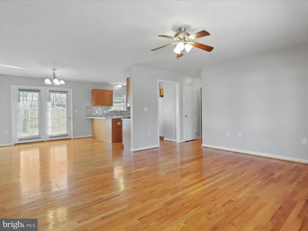 a view of empty room with wooden floor and window