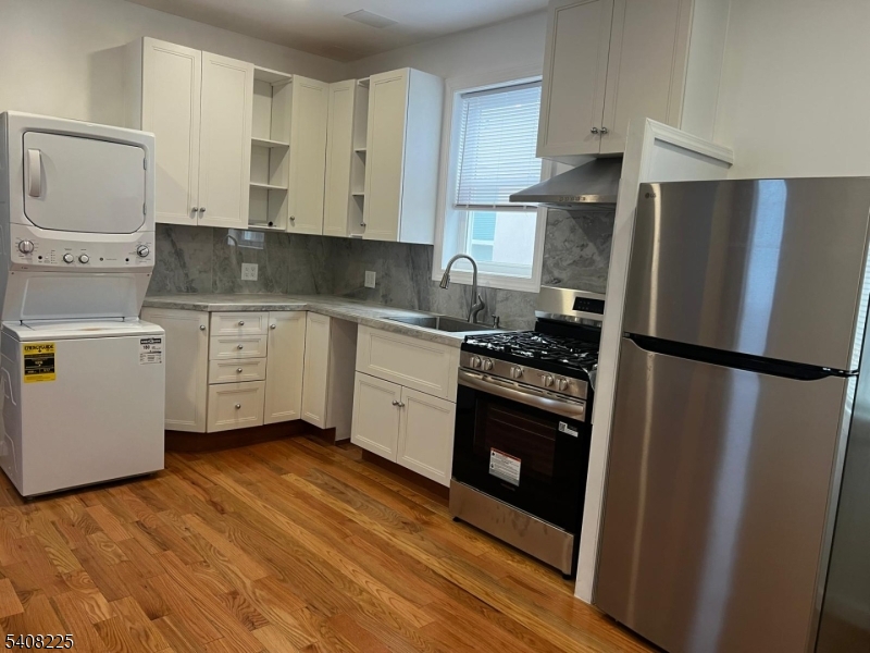 3 Montclair Avenue Paterson, NJ 07503 - Photo 5 of 17 a kitchen with a refrigerator sink and cabinets