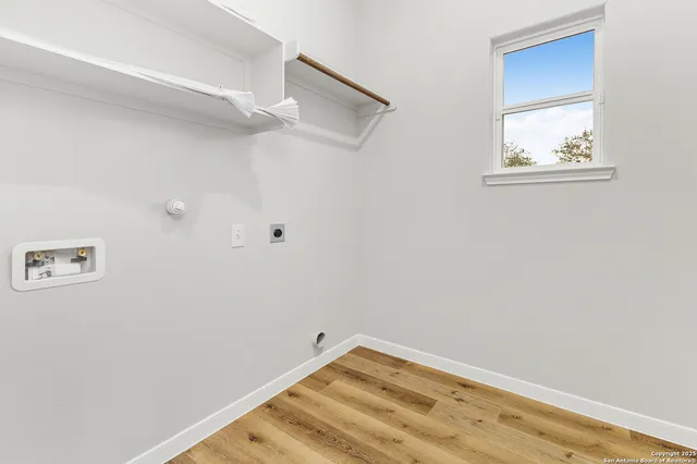 a view of a small space with wooden floor and a window