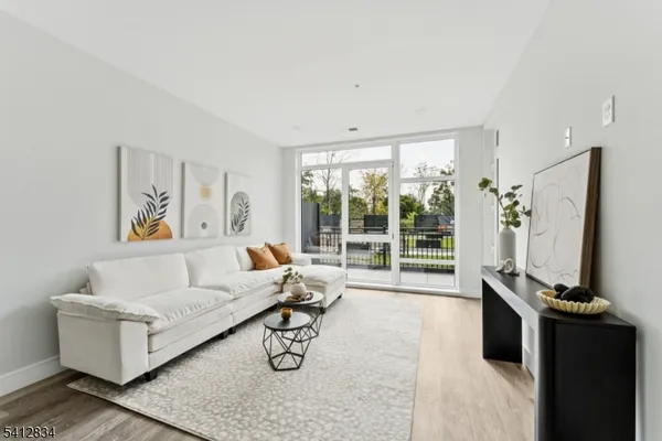 a living room with furniture a flat screen tv and a large window