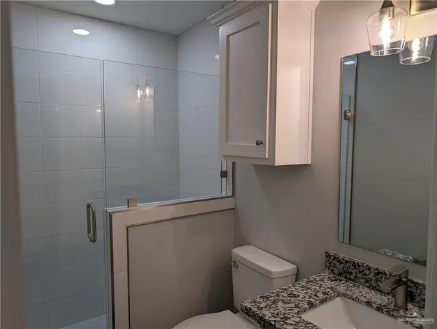 a bathroom with a toilet a sink and mirror