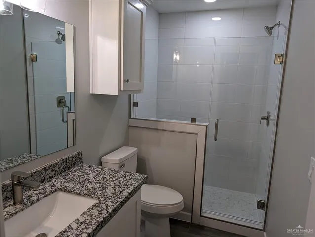 a bathroom with a granite countertop sink toilet and shower
