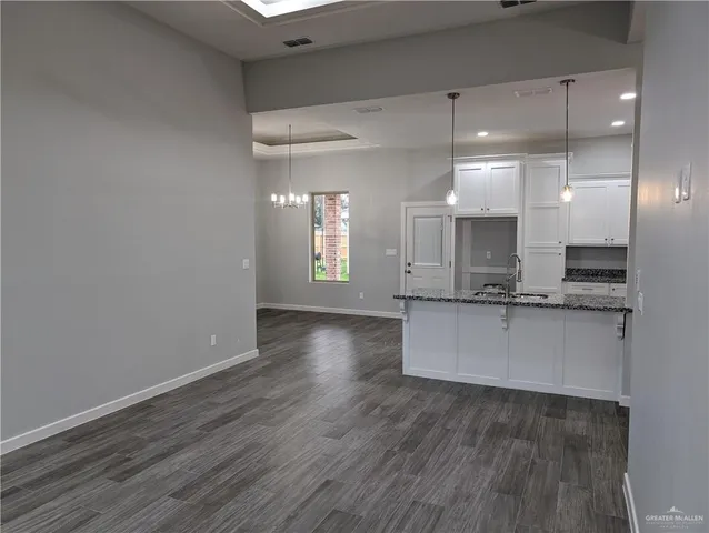 a large kitchen with a wooden floor and a sink