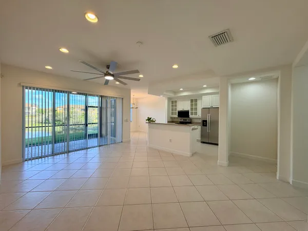 a view of a kitchen with kitchen island granite countertop a refrigerator and a sink