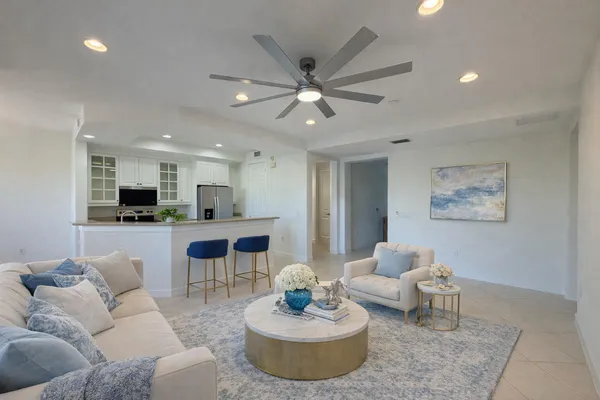 a living room with furniture and a view of kitchen