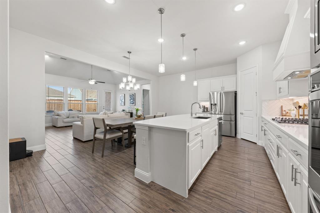 8808 Royal Star Road Rowlett, TX 75089 - Photo 19 of 40 a large white kitchen with lots of counter space dining table and chairs