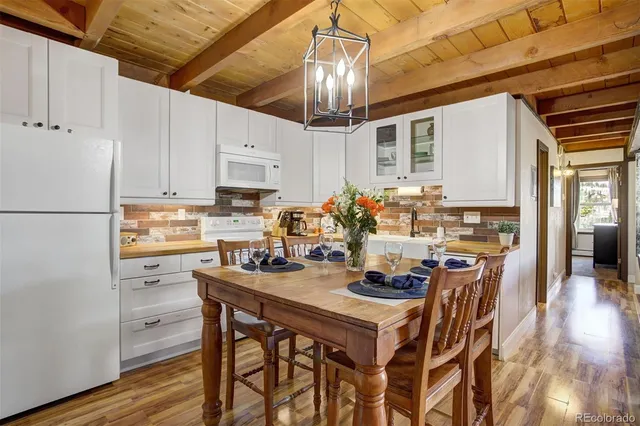 a kitchen with stainless steel appliances a dining table and chairs