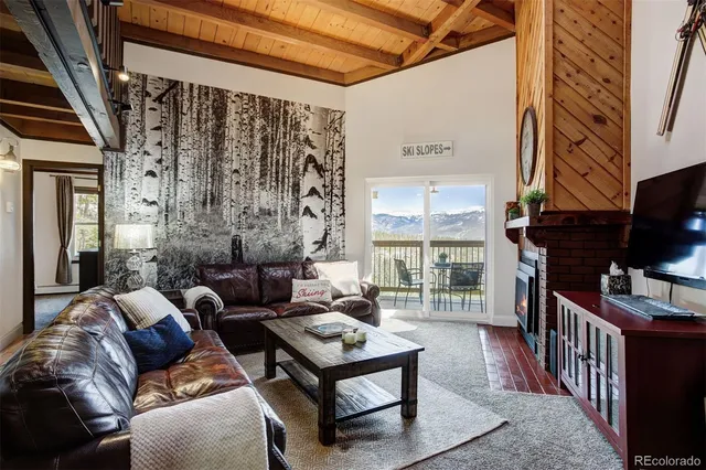 a living room with furniture a flat screen tv and a floor to ceiling window