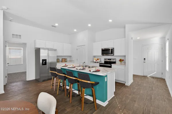 a kitchen with white cabinets and stainless steel appliances