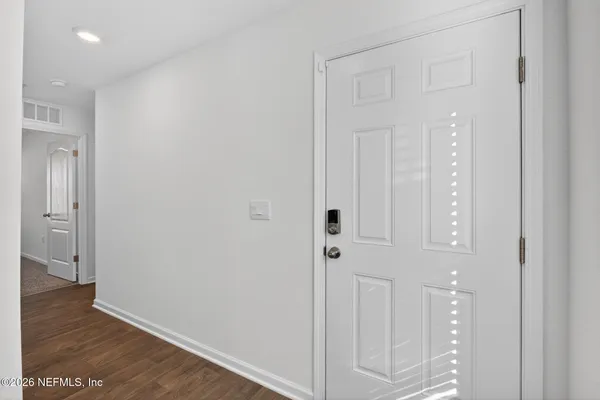 a view of a hallway with wooden floor