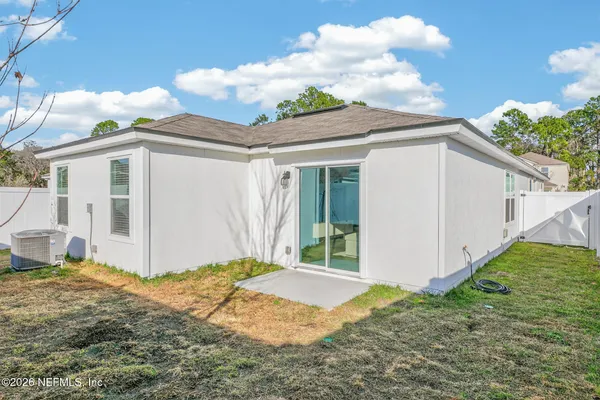 a backyard of a house with plants and barbeque oven