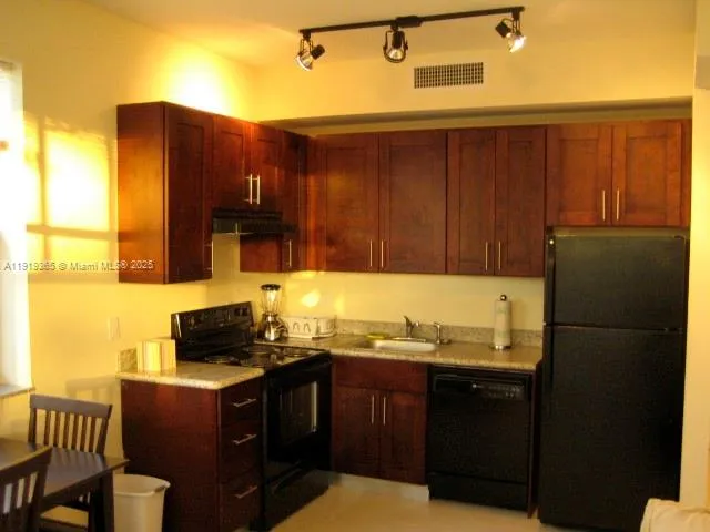 a kitchen with stainless steel appliances granite countertop a refrigerator and a stove top oven
