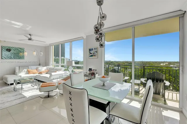a very nice looking living room with a large window and dining table