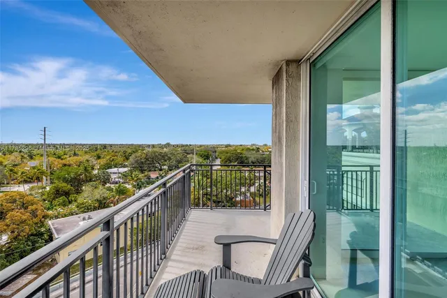 a view of a balcony with chair and floor to ceiling window