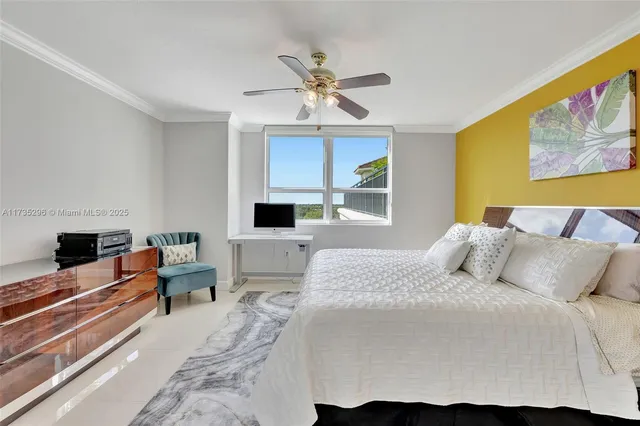 a bedroom with a bed a computer on table and a large window