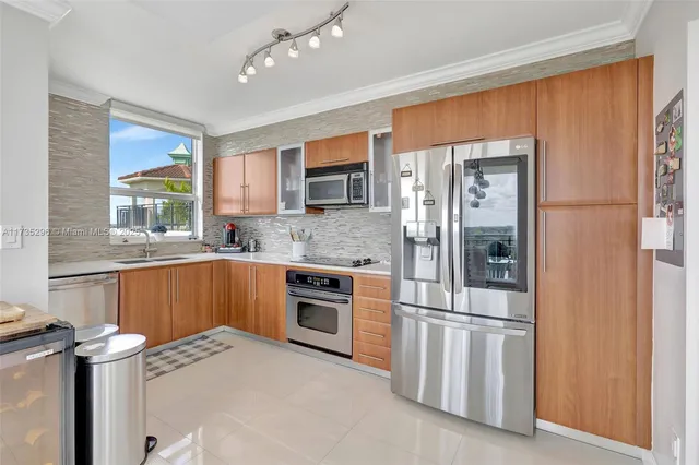 a kitchen with stainless steel appliances granite countertop a refrigerator and a sink