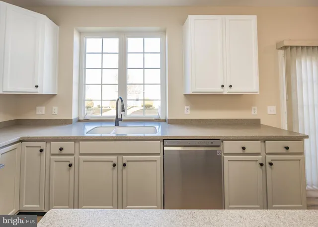 an empty room with wooden floor fireplace and windows