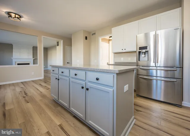 wooden floor fireplace and windows in an empty room