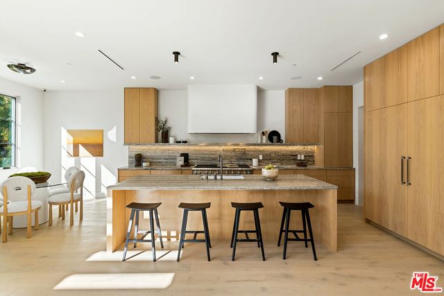 a kitchen with stainless steel appliances granite countertop a stove a sink and a white cabinets