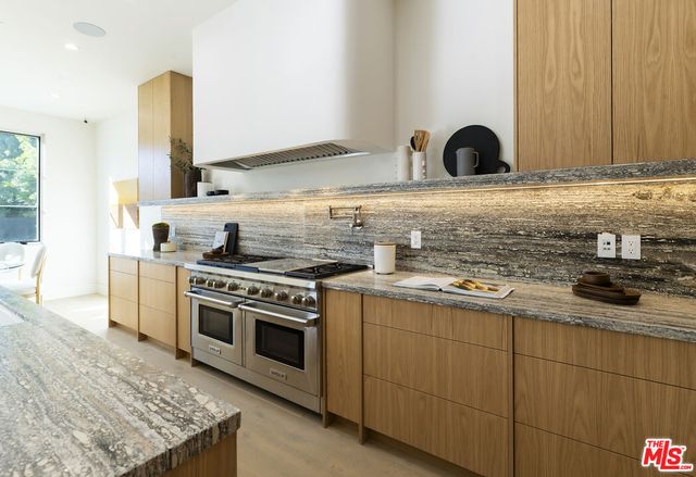 a kitchen with a table chairs sink and cabinets