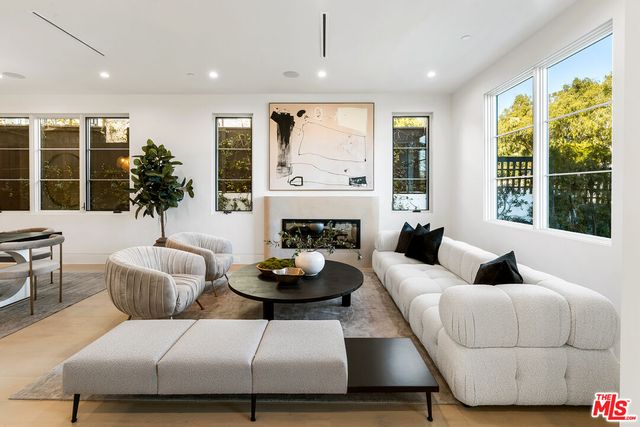 a living room with furniture potted plant and a large window