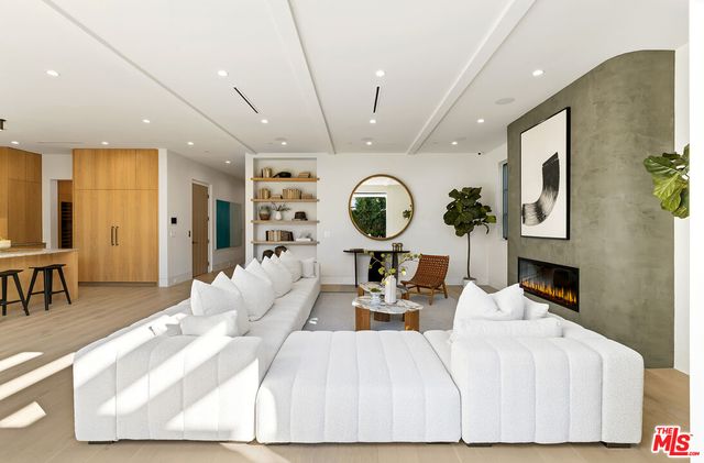 a kitchen with kitchen island granite countertop a table chairs sink and cabinets