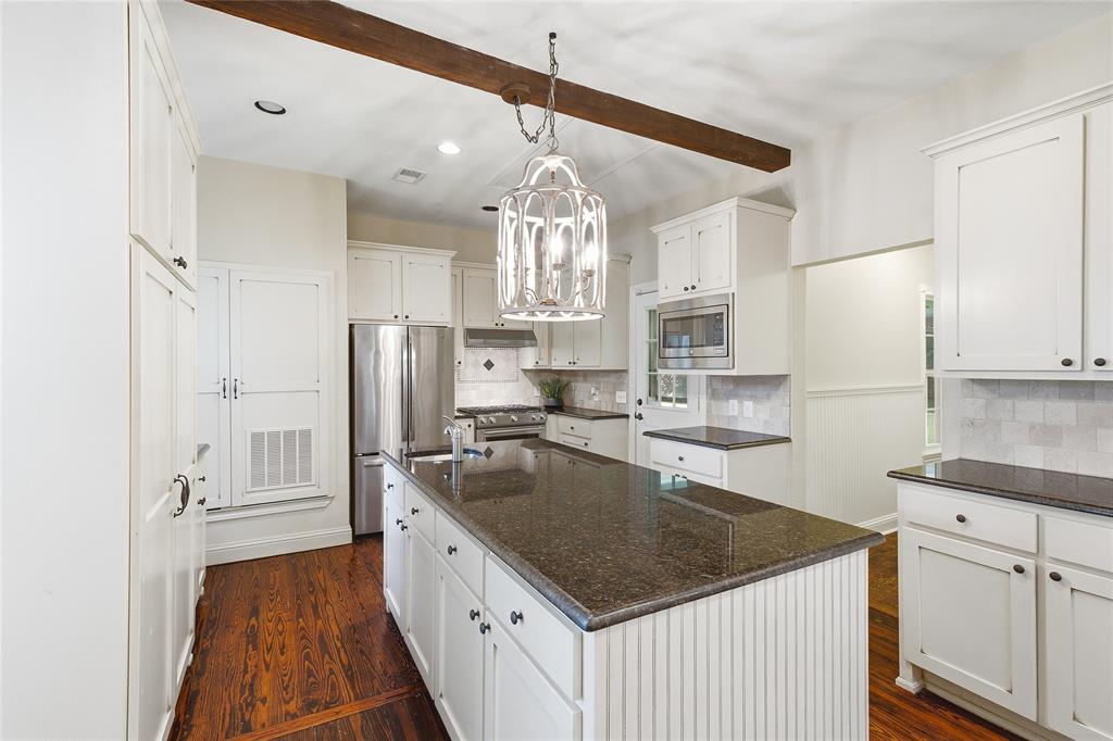 9121 6th Street Frisco, TX 75033 - Photo 6 of 27 a kitchen with white cabinets and stainless steel appliances