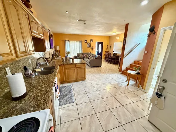 a kitchen with stainless steel appliances granite countertop a stove a sink and a microwave